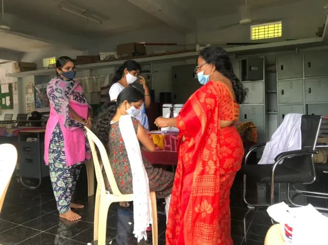 A teacher receiving her Covid-19 vaccination at school
