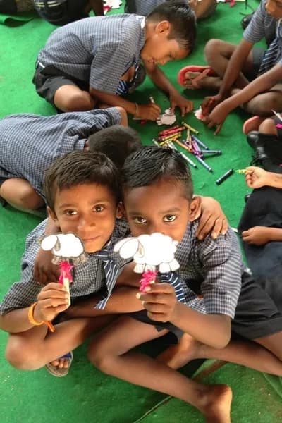 Two boys showing off their paper sheep crafts