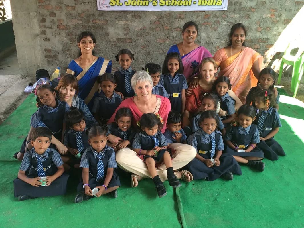 Valerie and Tracey with staff and students under the St. John's School - India banner