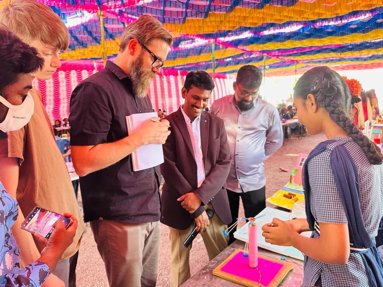 Visitors reviewing a student's science fair project